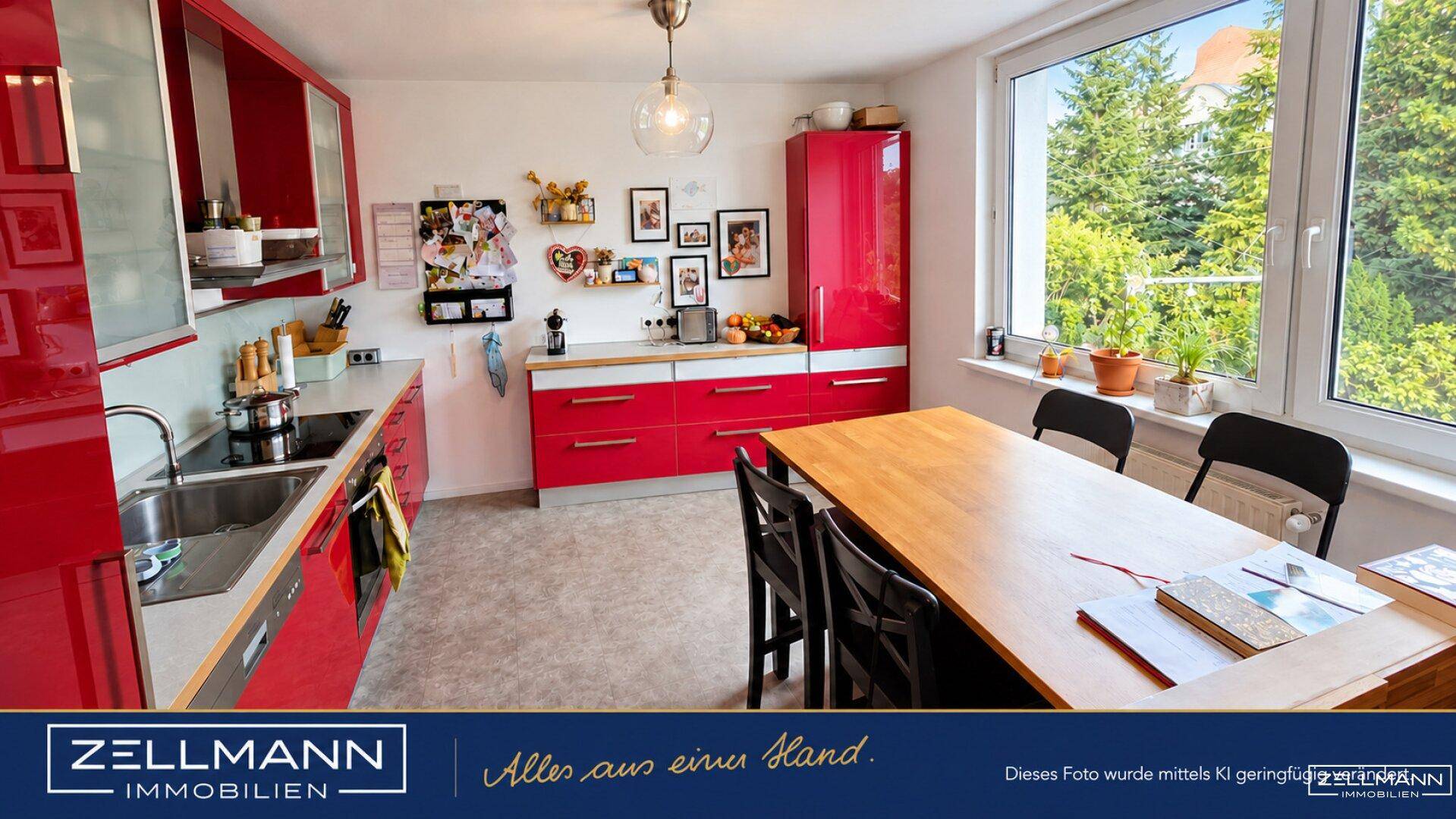 Moderne Küche mit roten Hochglanzfronten, Essbereich und Blick ins Grüne.