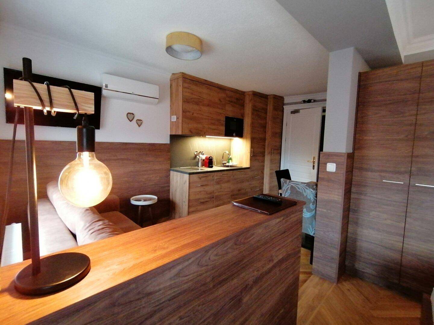 Studio-Apartment mit Schlafbereich, Küchenzeile und modernem Beleuchtungskonzept.