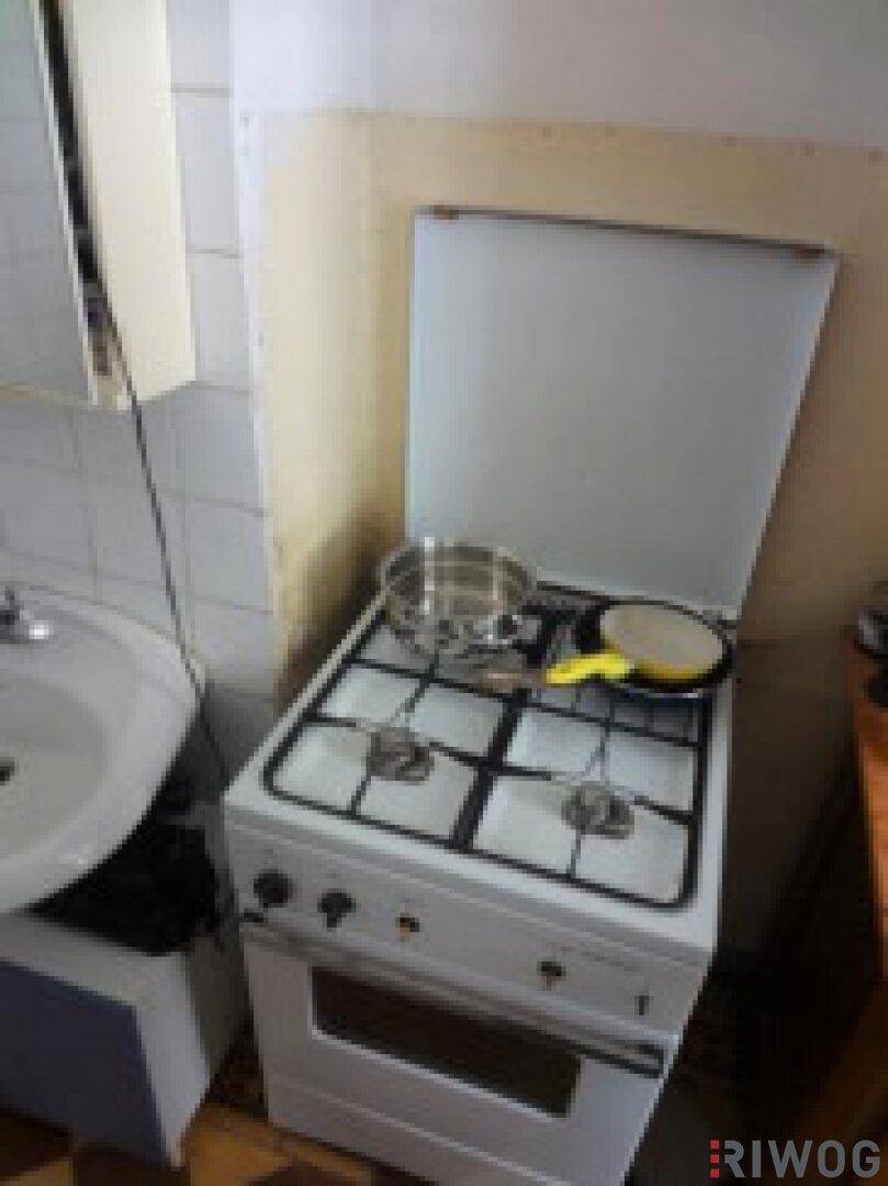 Kleiner Gasherd mit Backofen in einer einfachen Küchenzeile.