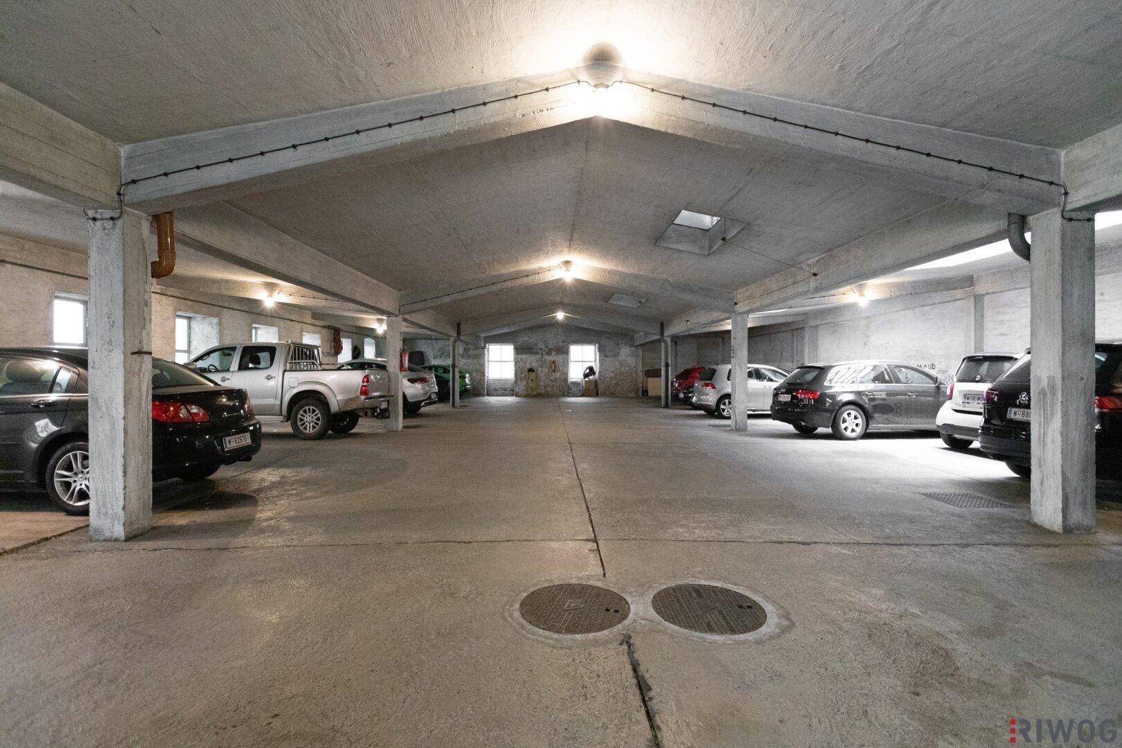 Geräumige Tiefgarage mit vielen Stellplätzen für Fahrzeuge und Betonkonstruktion.