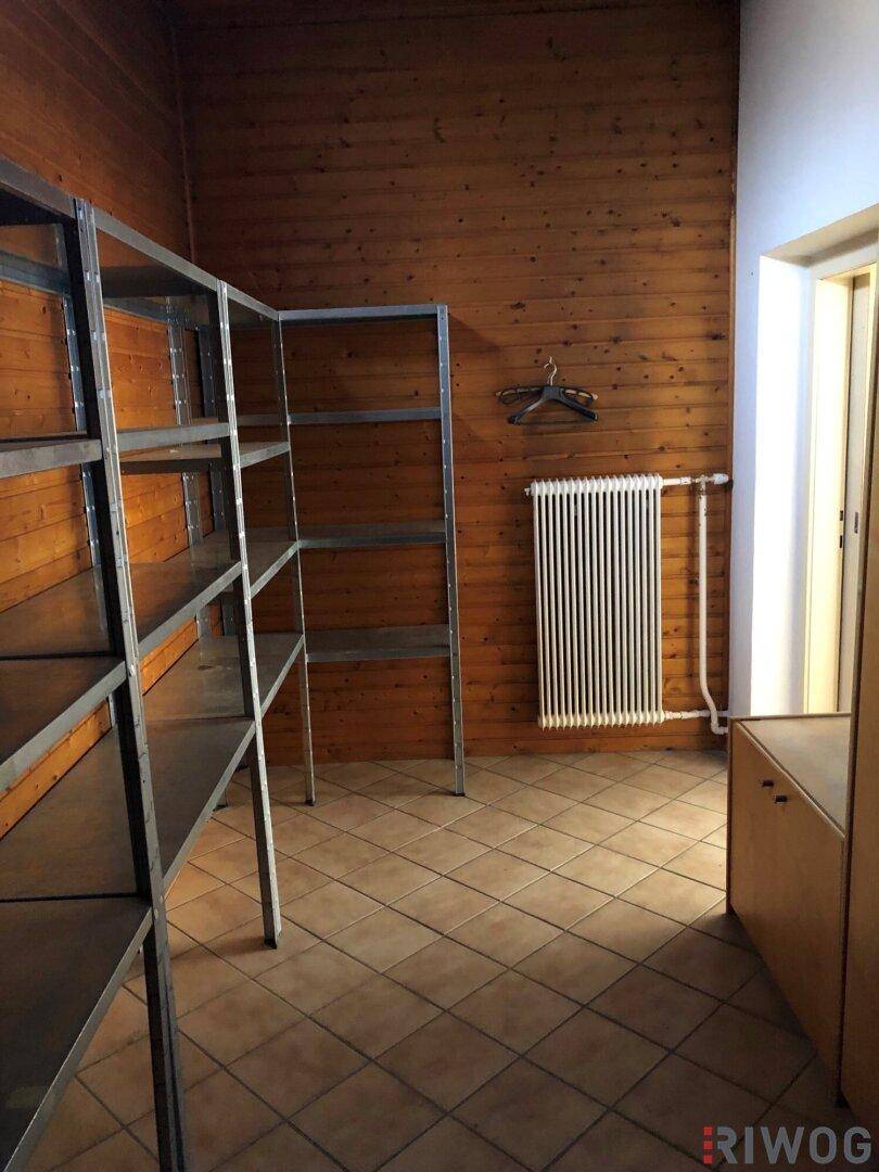 Lagerraum mit Holzverkleidung, Fliesenboden und stabilen Metallregalen.