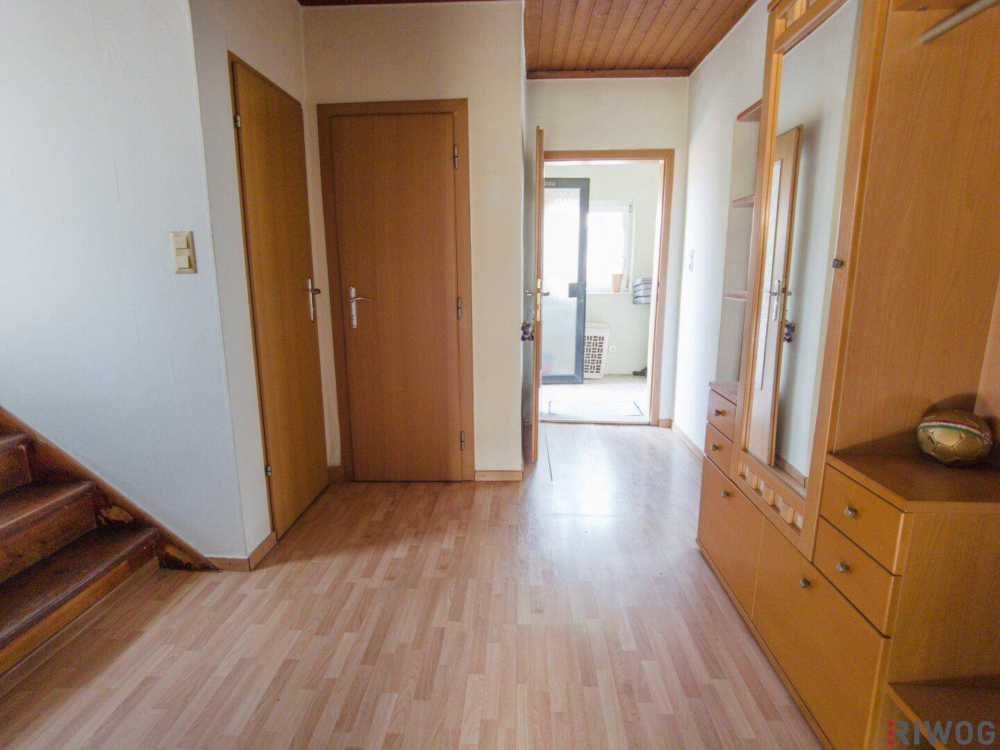 Geräumiger Flur mit Laminatboden und Holzdecke, ausgestattet mit einem Garderobenschrank.