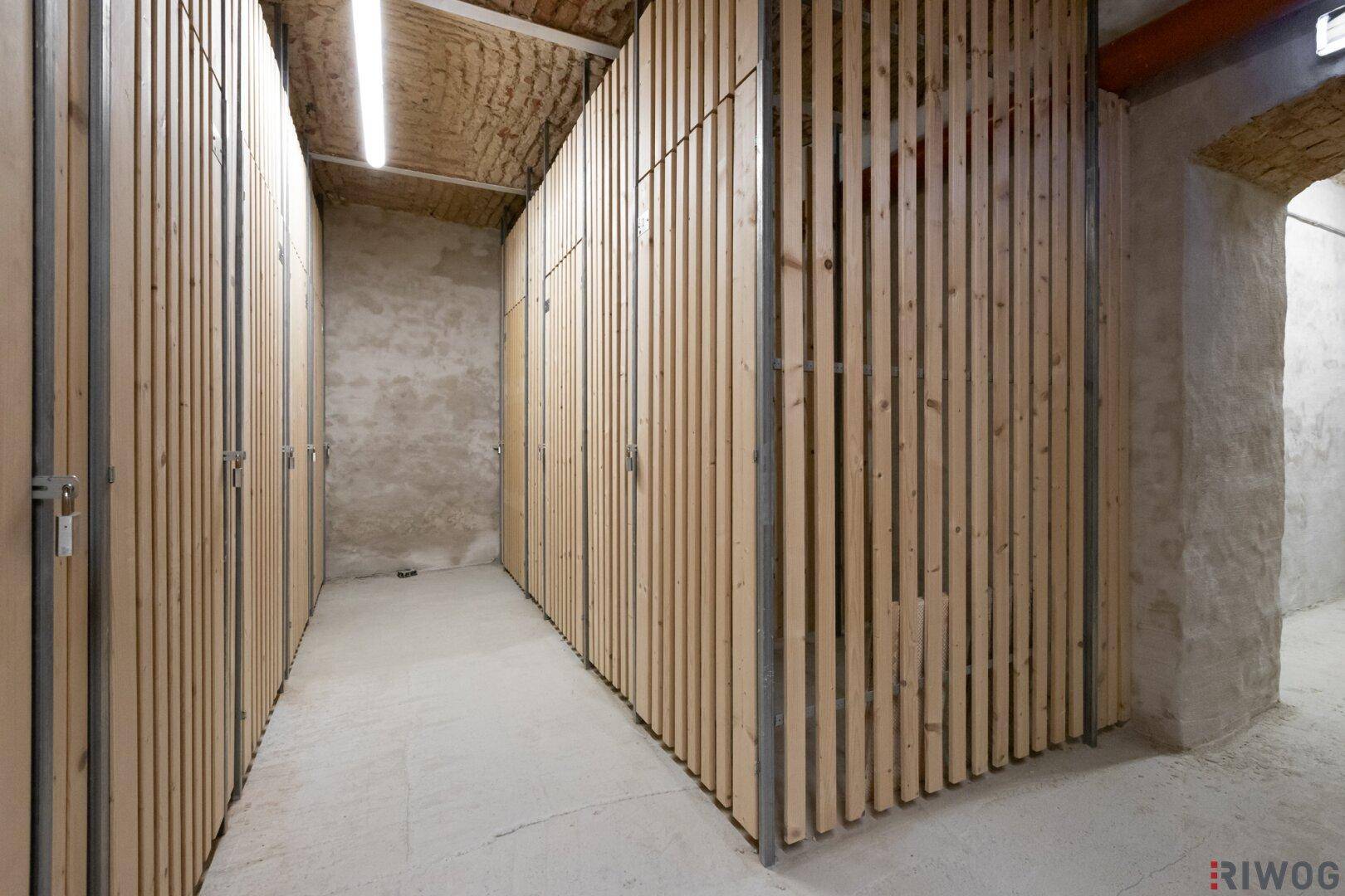 Kellerabteile mit Holzlamellenwänden, bieten zusätzlichen Stauraum für Bewohner.