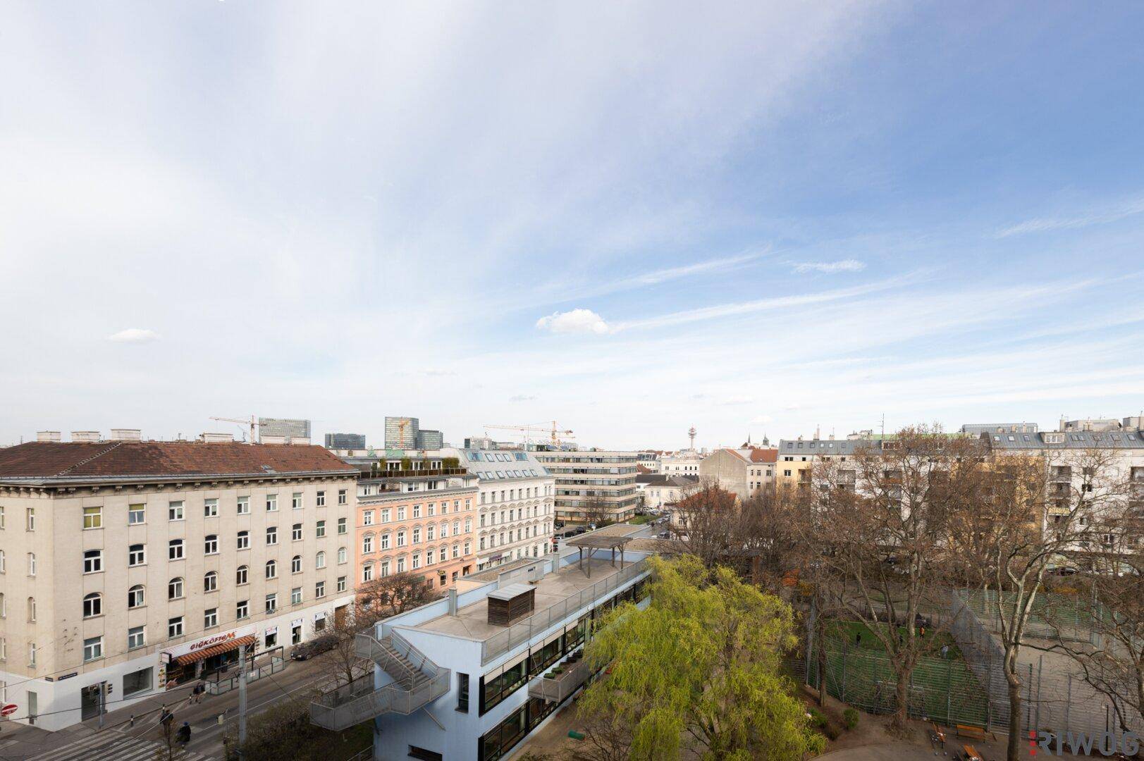 Weitläufiger Blick über die Stadt mit Parkanlagen und umliegenden Gebäuden.