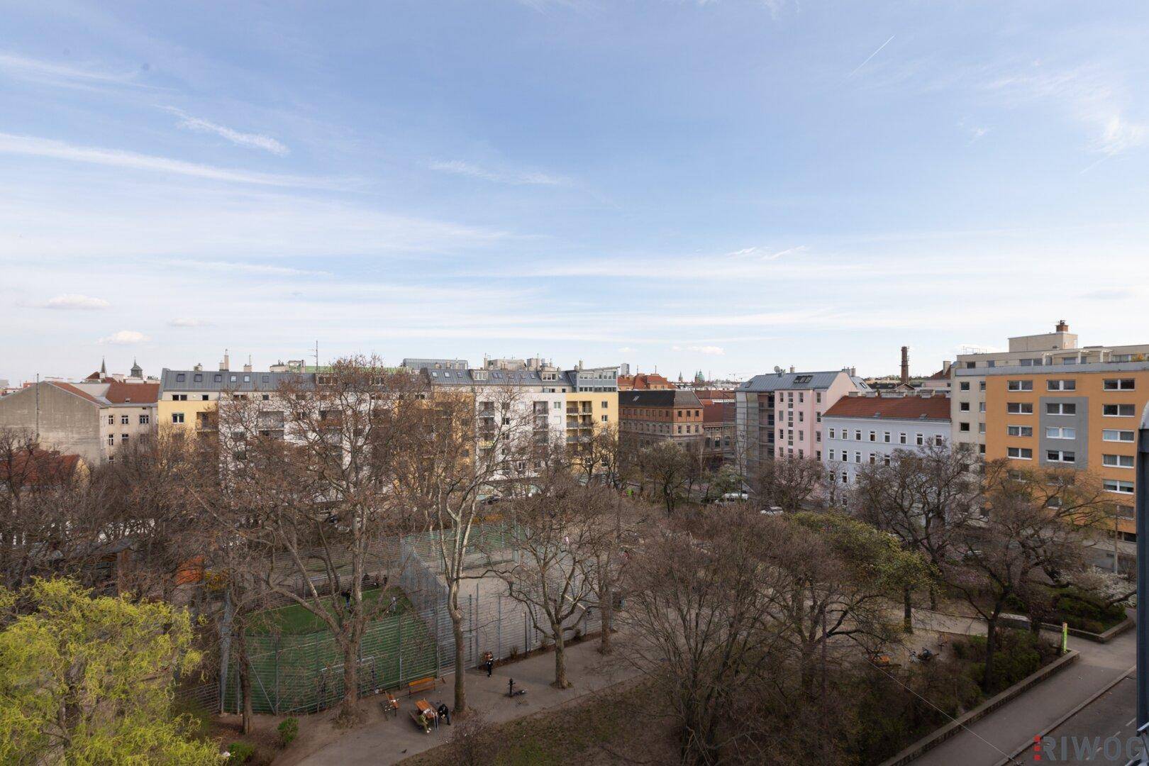 Weitläufiger Blick über die Stadt mit Parkanlagen und umliegenden Gebäuden.