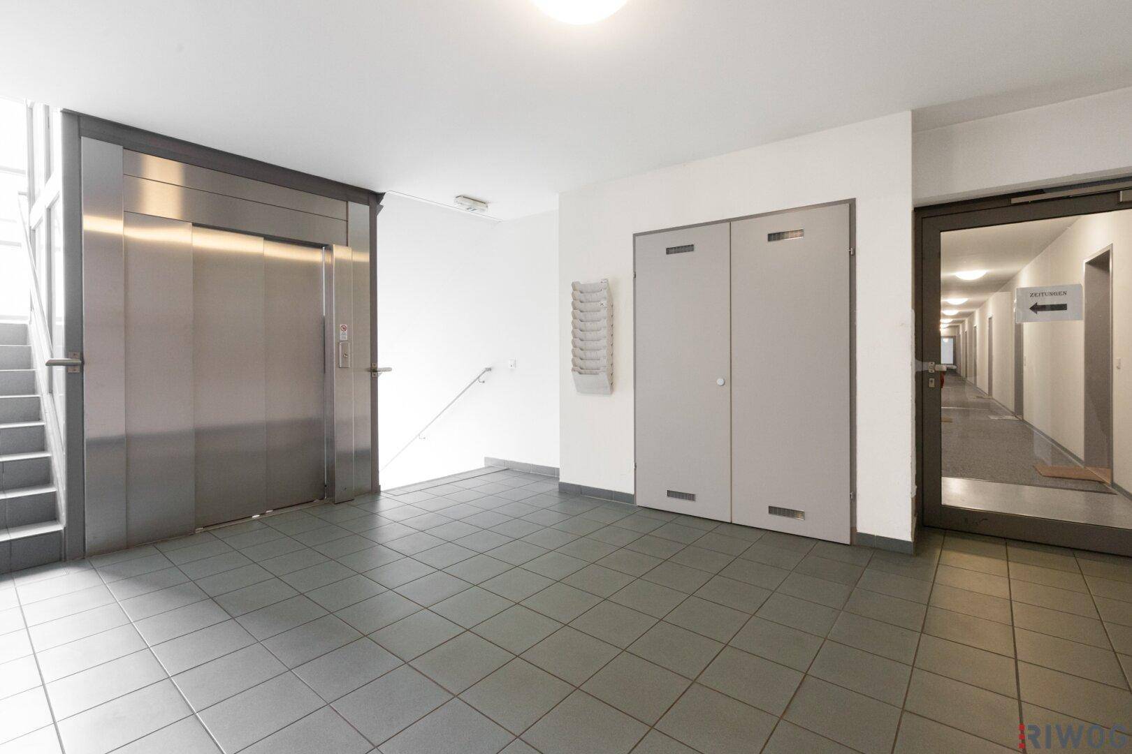 Heller Eingangsbereich im Gebäude mit Aufzug und Zugang zu den Wohnungen.