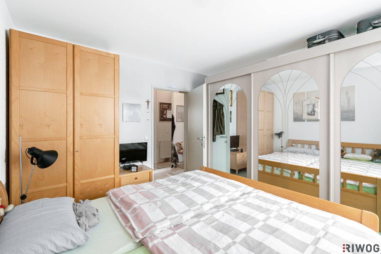 Helles Schlafzimmer mit Holzschränken und Doppelbett, bietet eine ruhige Rückzugsmöglichkeit.