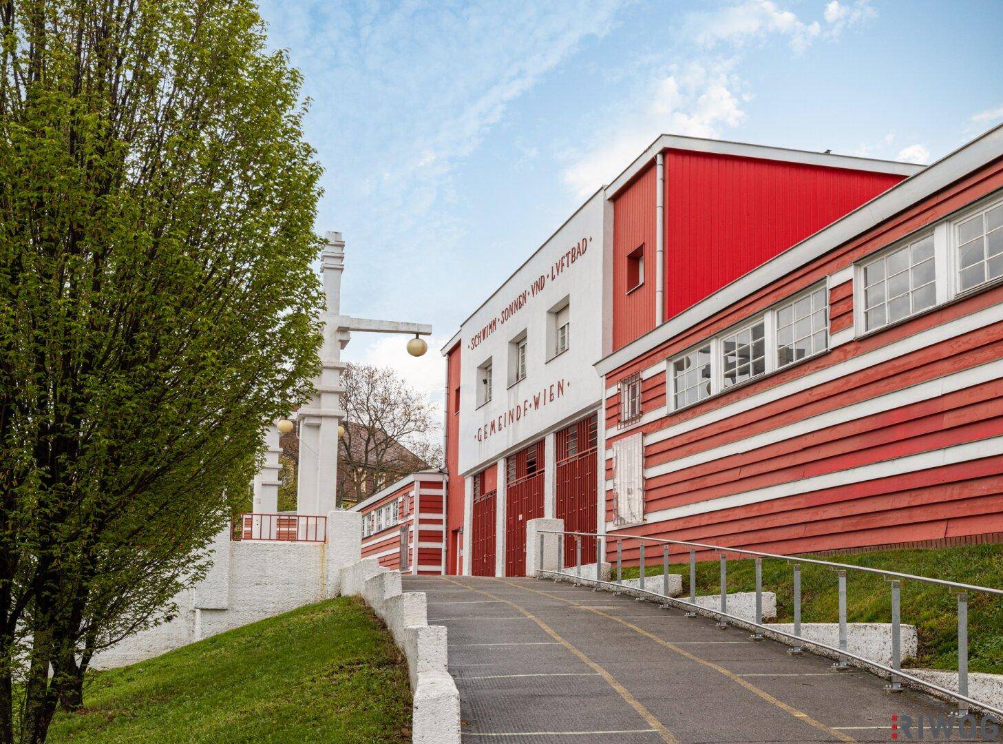 Historisches Gebäude mit roter und weißer Fassade und Rampe.