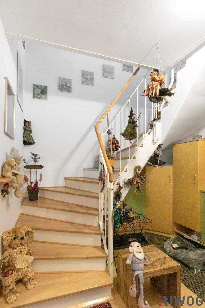 Helle Holztreppe im Eingangsbereich, führt zu den oberen Etagen.