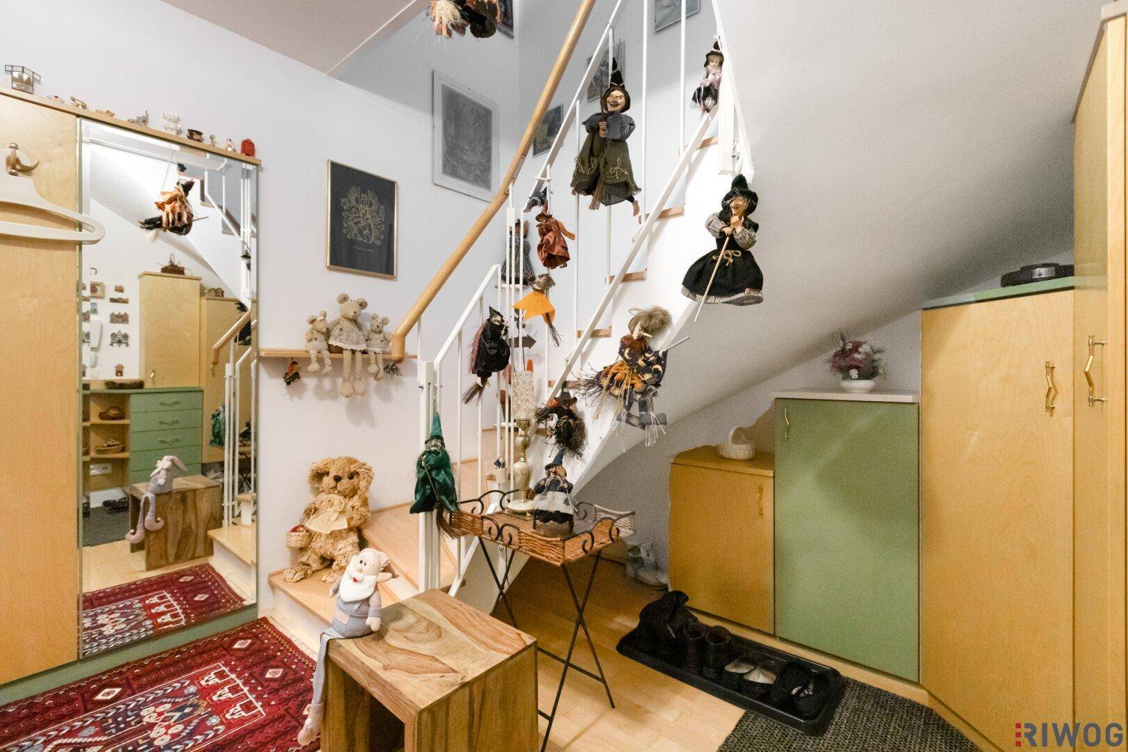 Eingangsbereich mit Treppe, Holzgeländer und dekorativen Elementen.