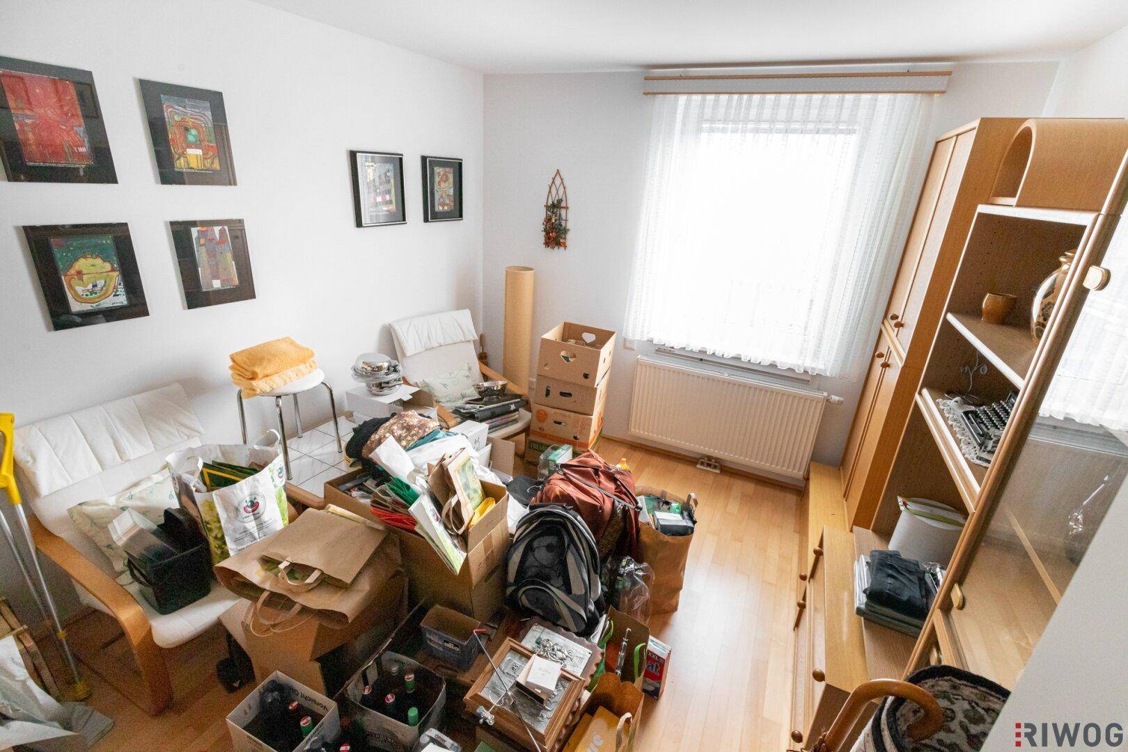 Raum mit Holzboden und Fenster, derzeit als Abstellraum genutzt.