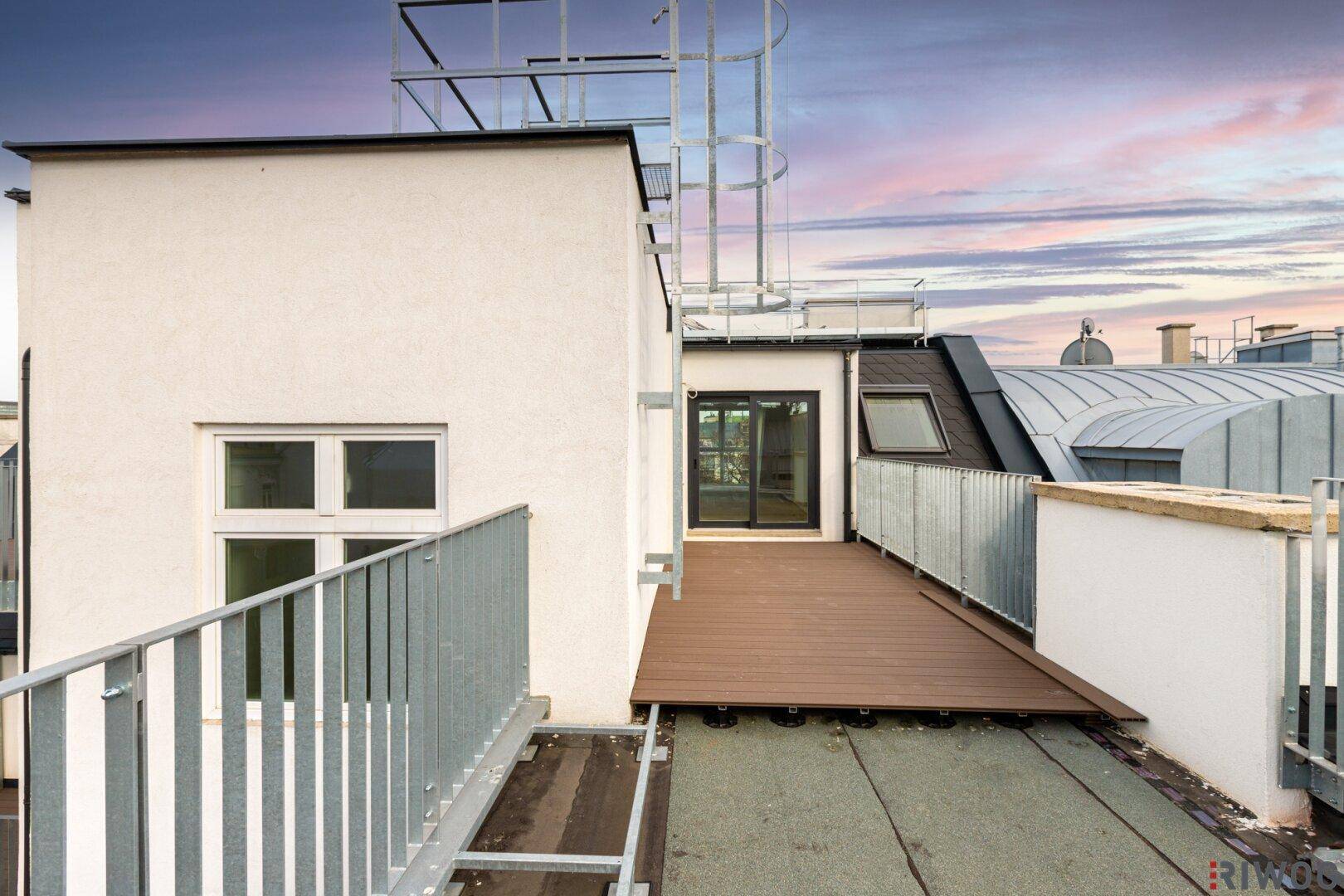 Dachterrasse mit Zugang zum Innenraum und Blick auf die umliegenden Gebäude.