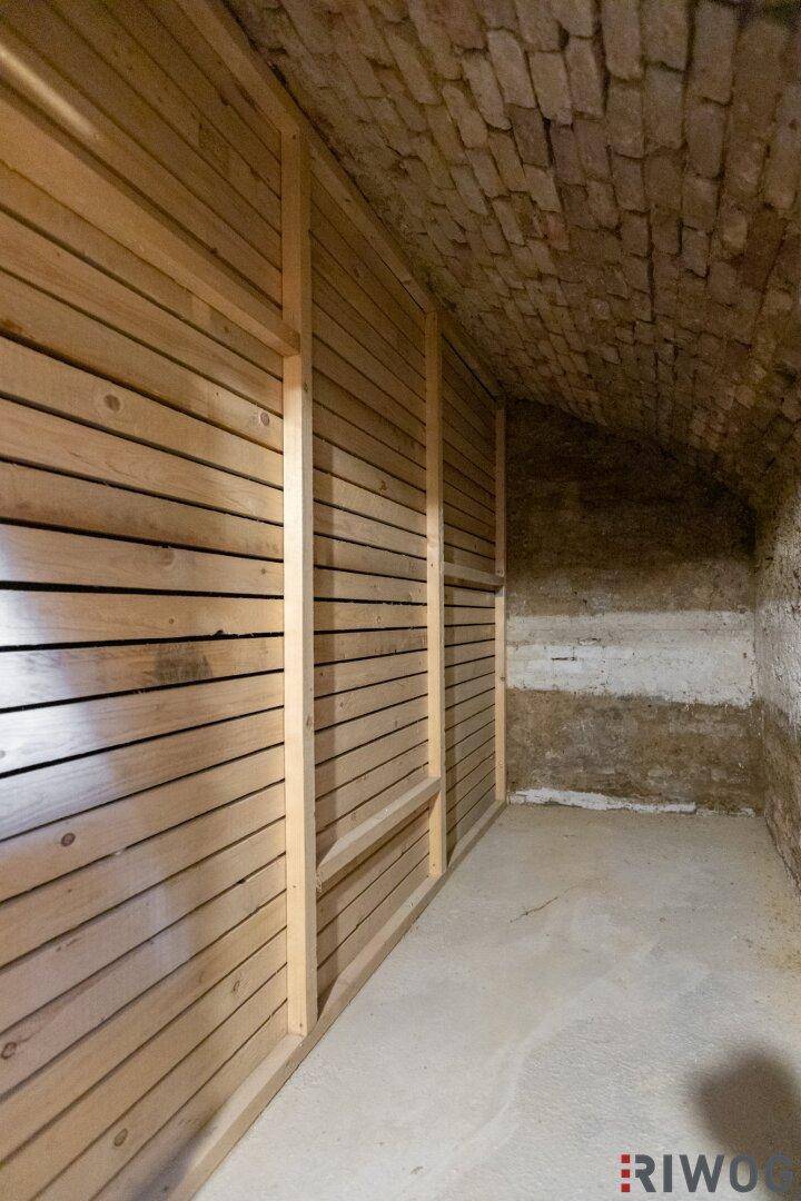 Leeres Kellerabteil mit Holzwänden und gemauertem Gewölbe, bereit zur Nutzung.