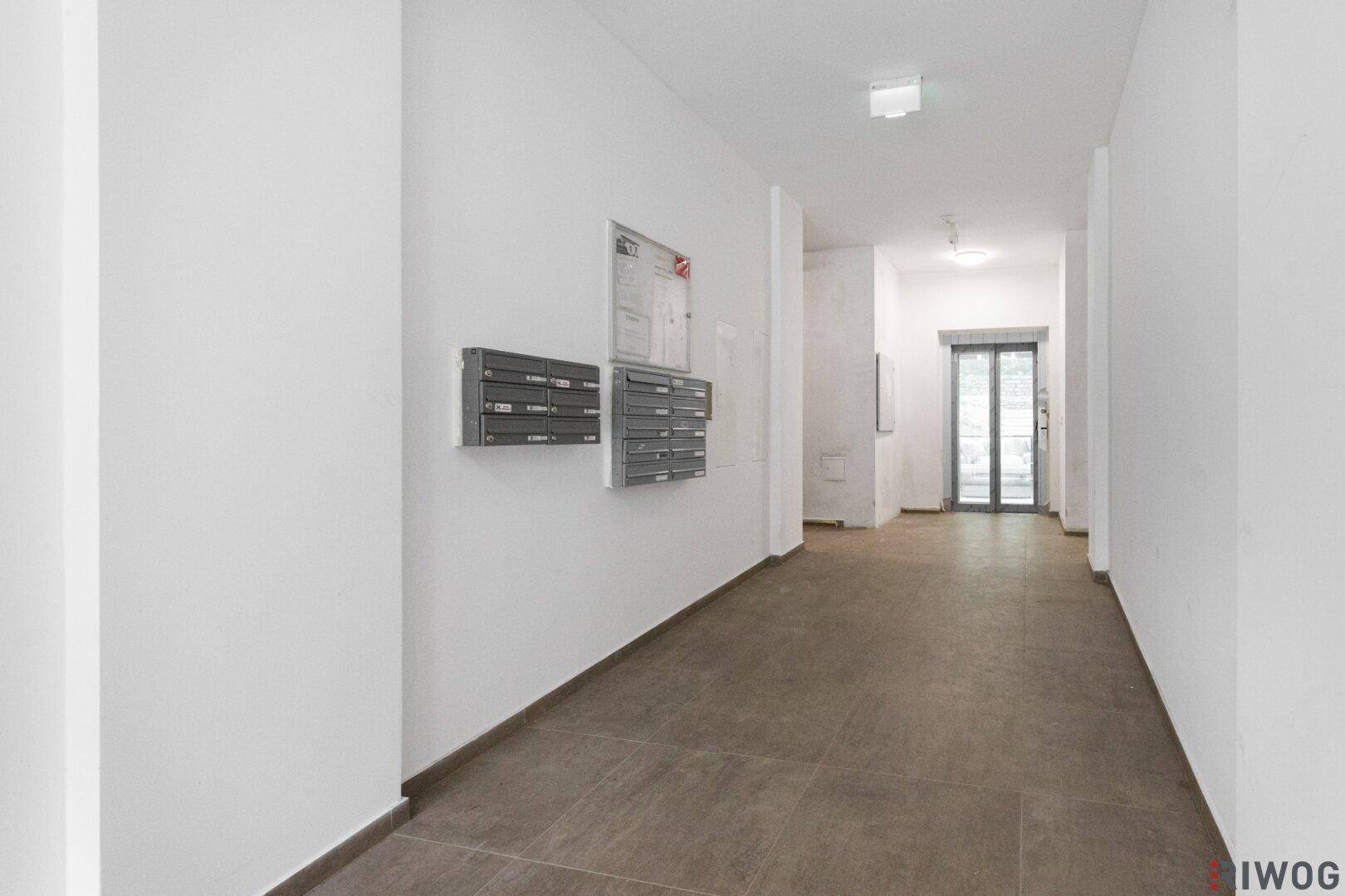 Eingangsbereich des Gebäudes mit Briefkästen und Fliesenboden.