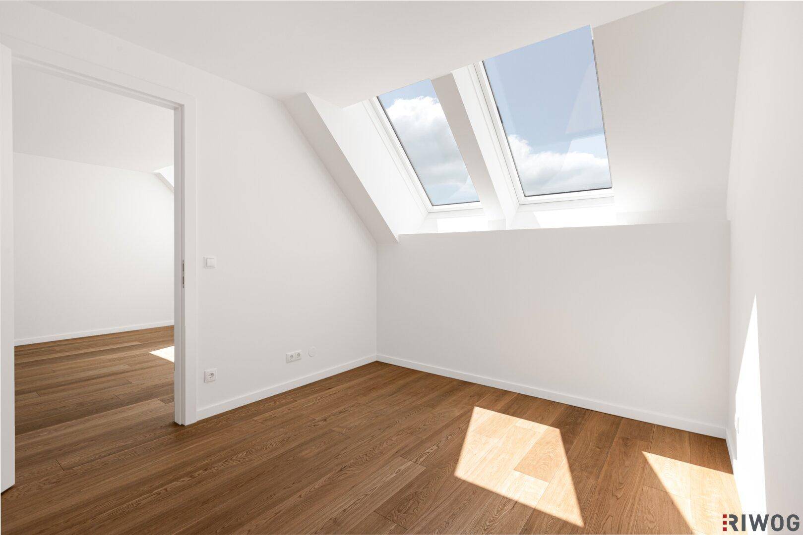Helles Zimmer mit Holzboden und großen Dachfenstern, ideal für ein Schlafzimmer im Dachgeschoss.