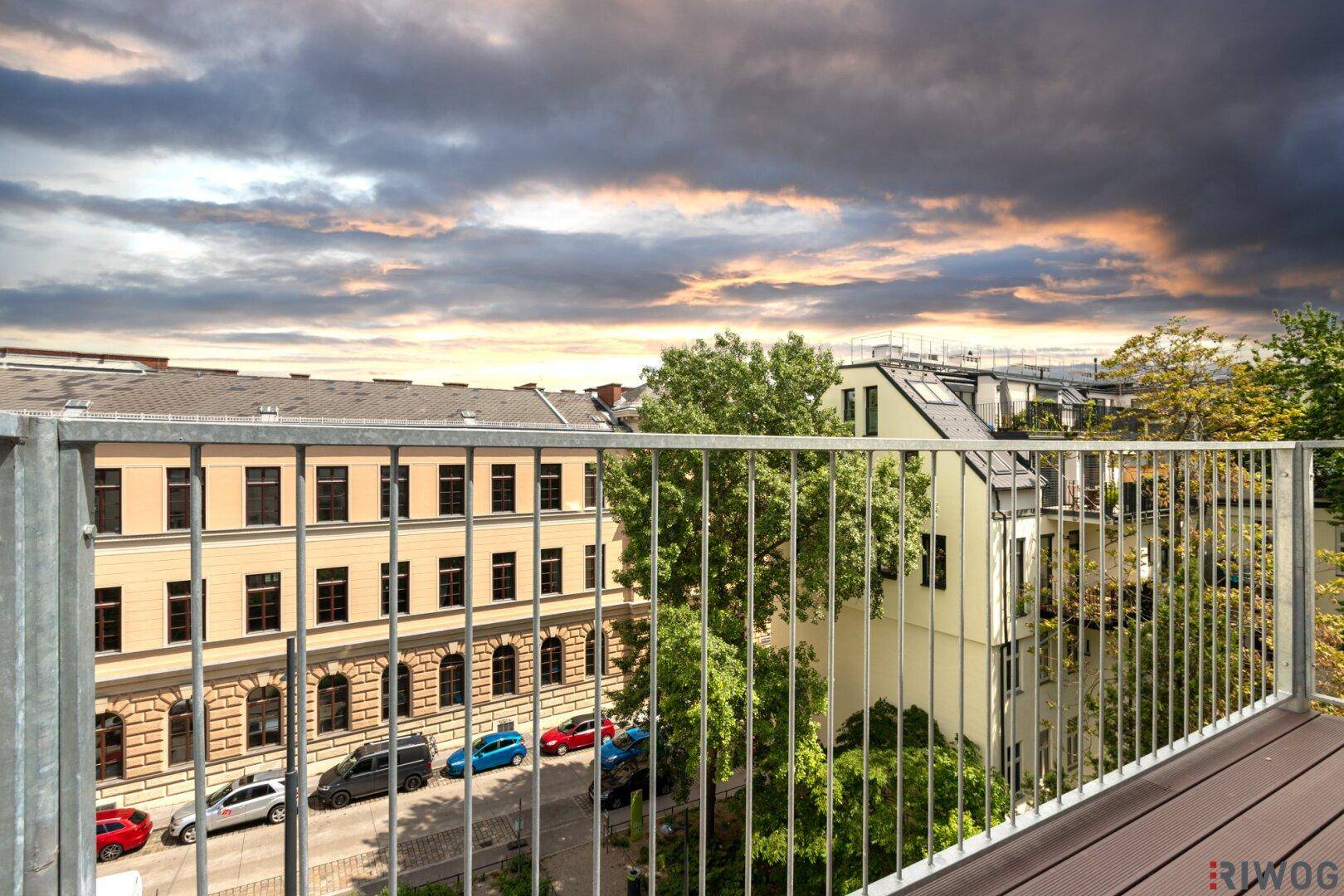 Balkon mit weitem Blick über die Stadt und den Himmel bei Sonnenuntergang.