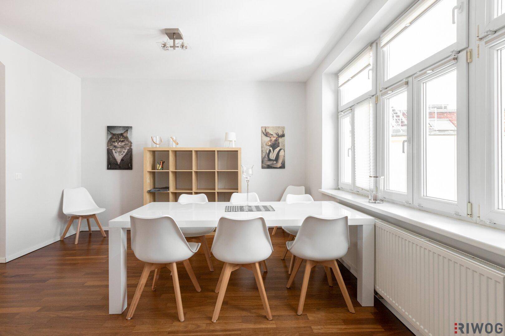 Heller Essbereich mit großem Tisch, modernen Stühlen und viel Tageslicht durch die Fenster.