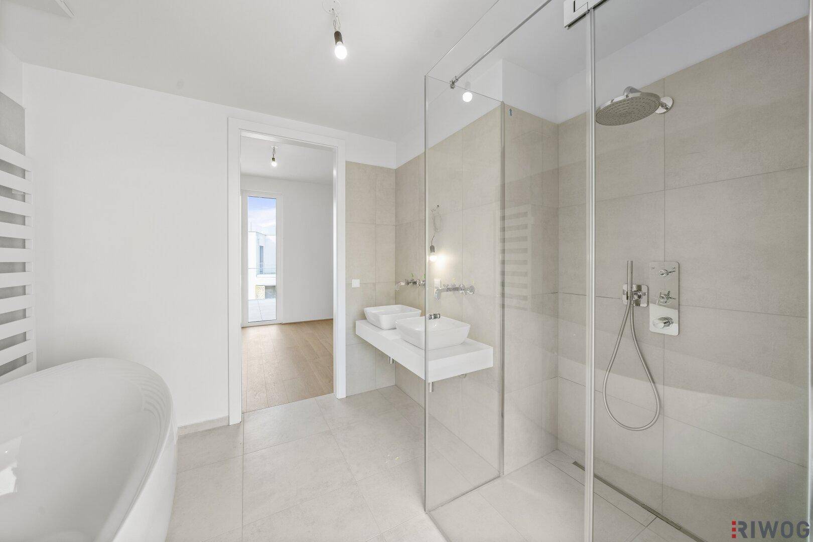 Elegantes Badezimmer mit großer Glasdusche, Doppelwaschbecken und moderner Ausstattung.