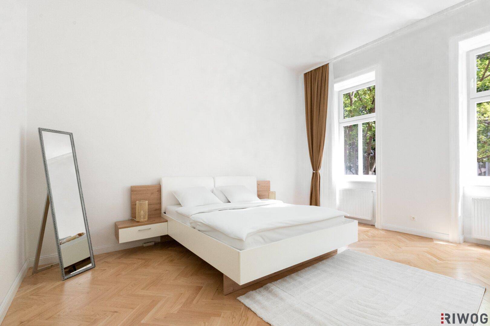 Helles Schlafzimmer mit modernem Bett, Parkettboden und einem großen Spiegel.