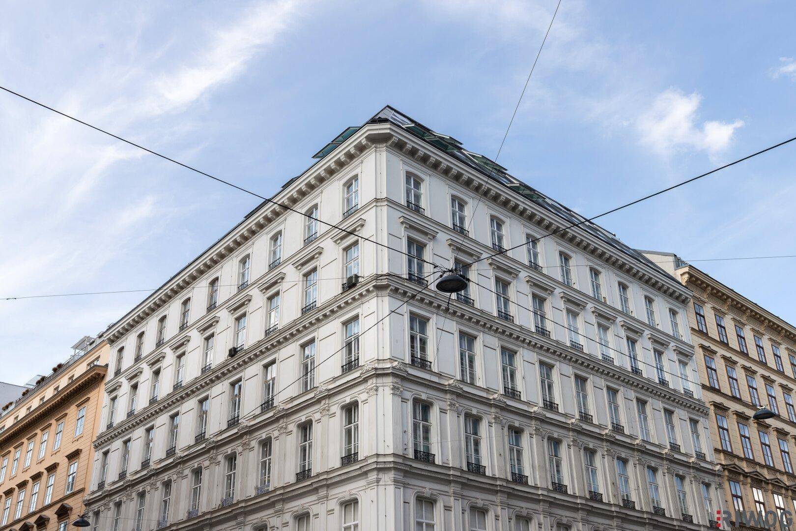 Eindrucksvolles Eckgebäude mit klassischer Architektur und modernen Dachfenstern.