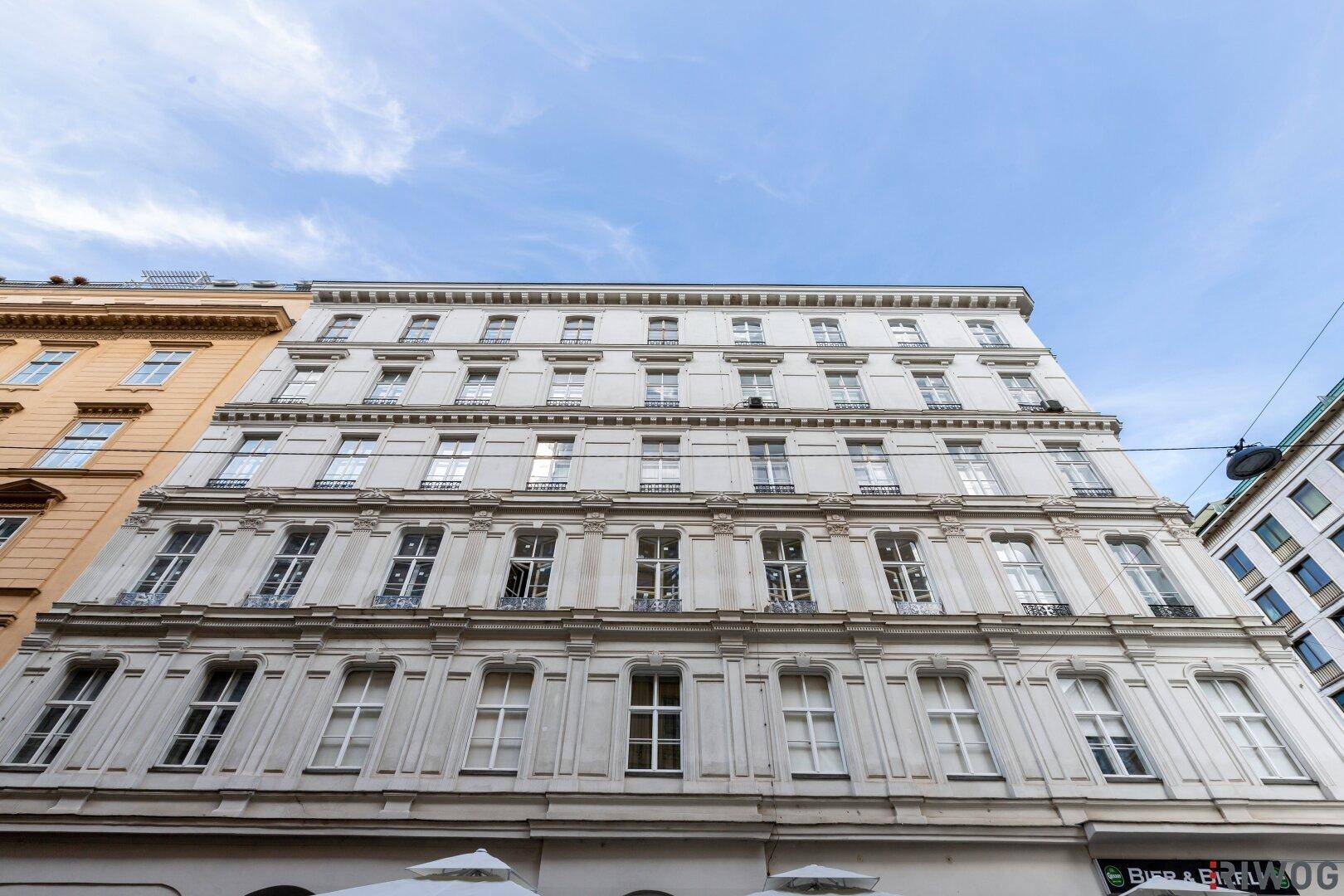 Detailansicht der historischen Fassade mit vielen Fenstern und klassischer Architektur.