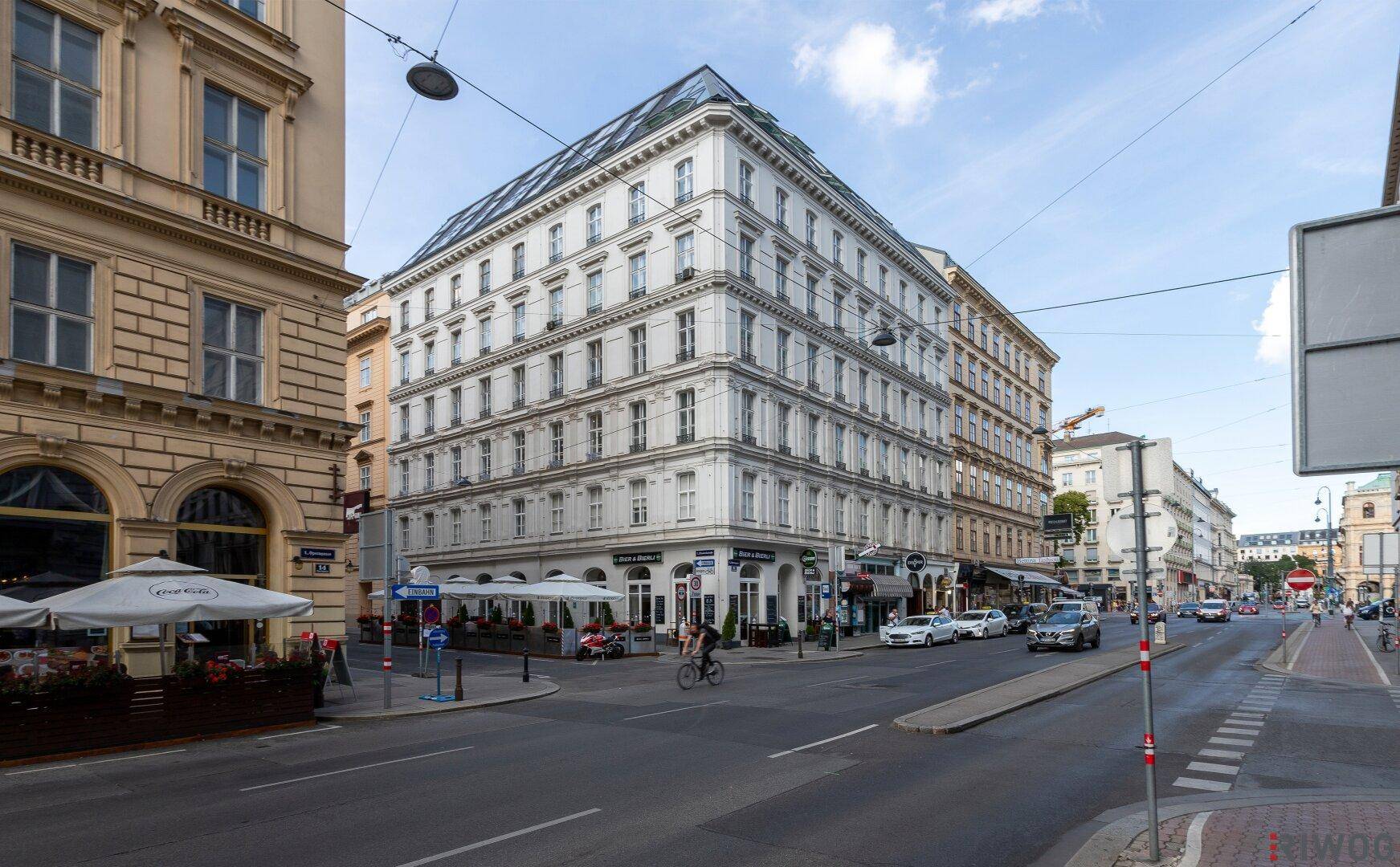Weitläufige Ansicht des historischen Gebäudes an einer belebten Stadtstraße.