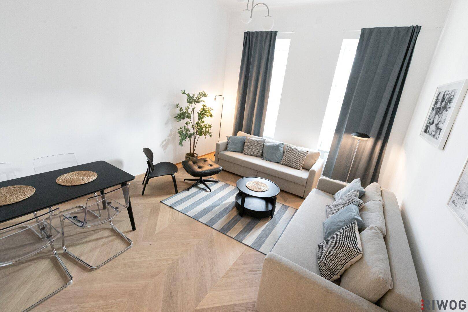 Geräumiger Wohn- und Essbereich mit Holzboden, Teppich und moderner Einrichtung.