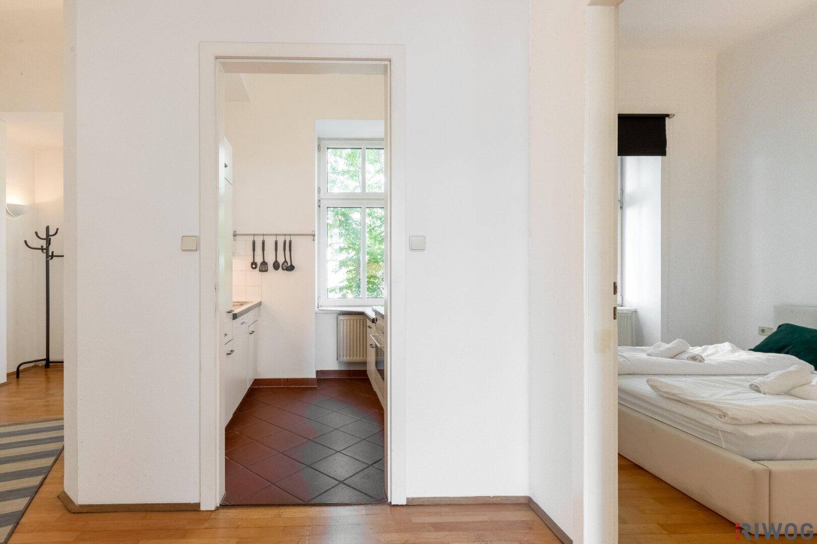 Flur mit Parkettboden, der den Zugang zur Küche und zum Schlafzimmer ermöglicht.