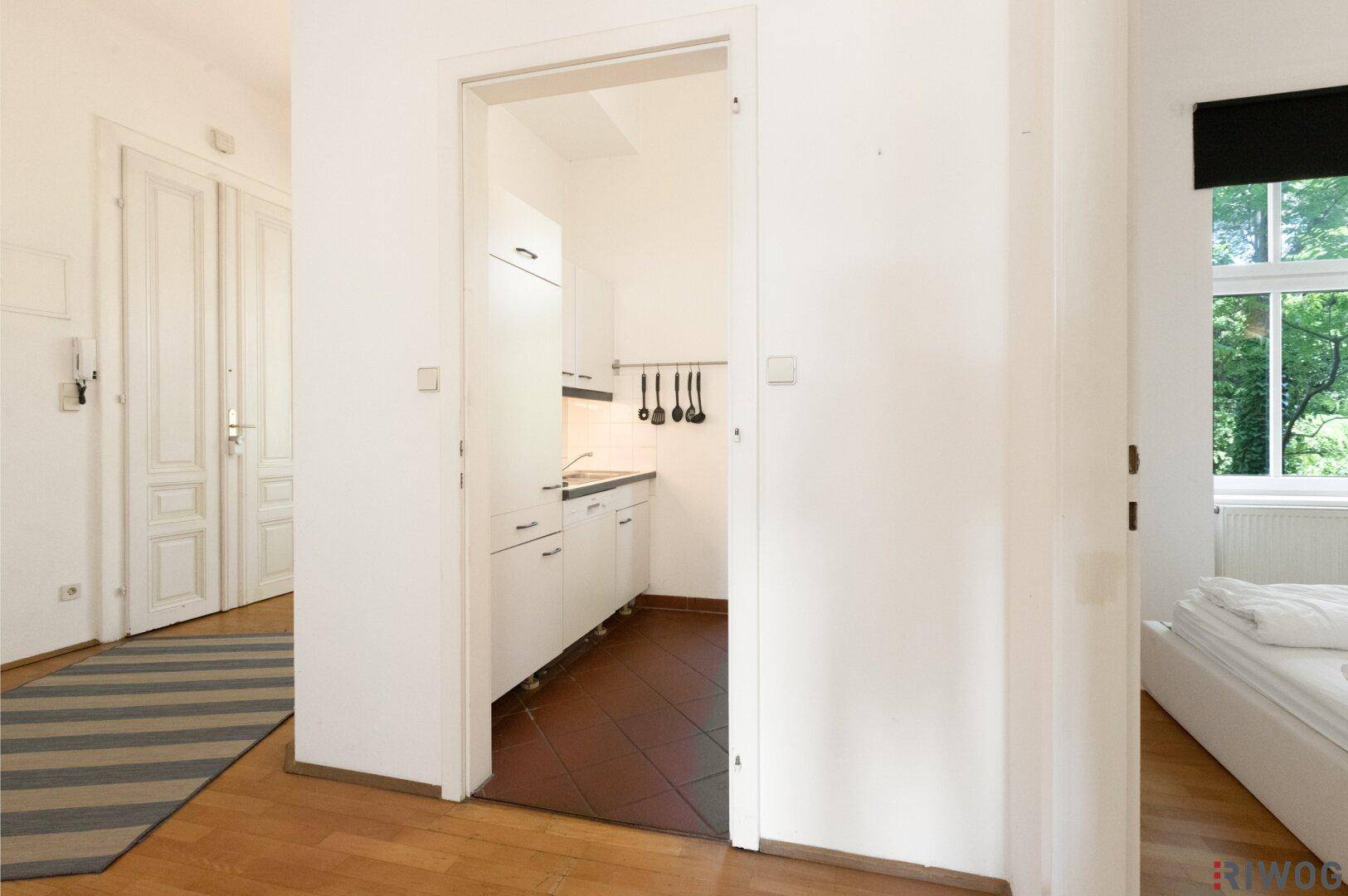 Flur mit Parkettboden, der den Zugang zur Küche und zum Schlafzimmer ermöglicht.