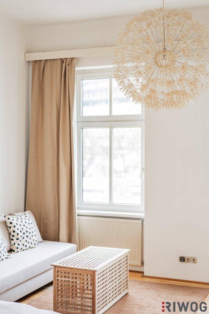 Nahaufnahme des Fensters mit Vorhängen und einem Teil des Sofas im hellen Wohnbereich.
