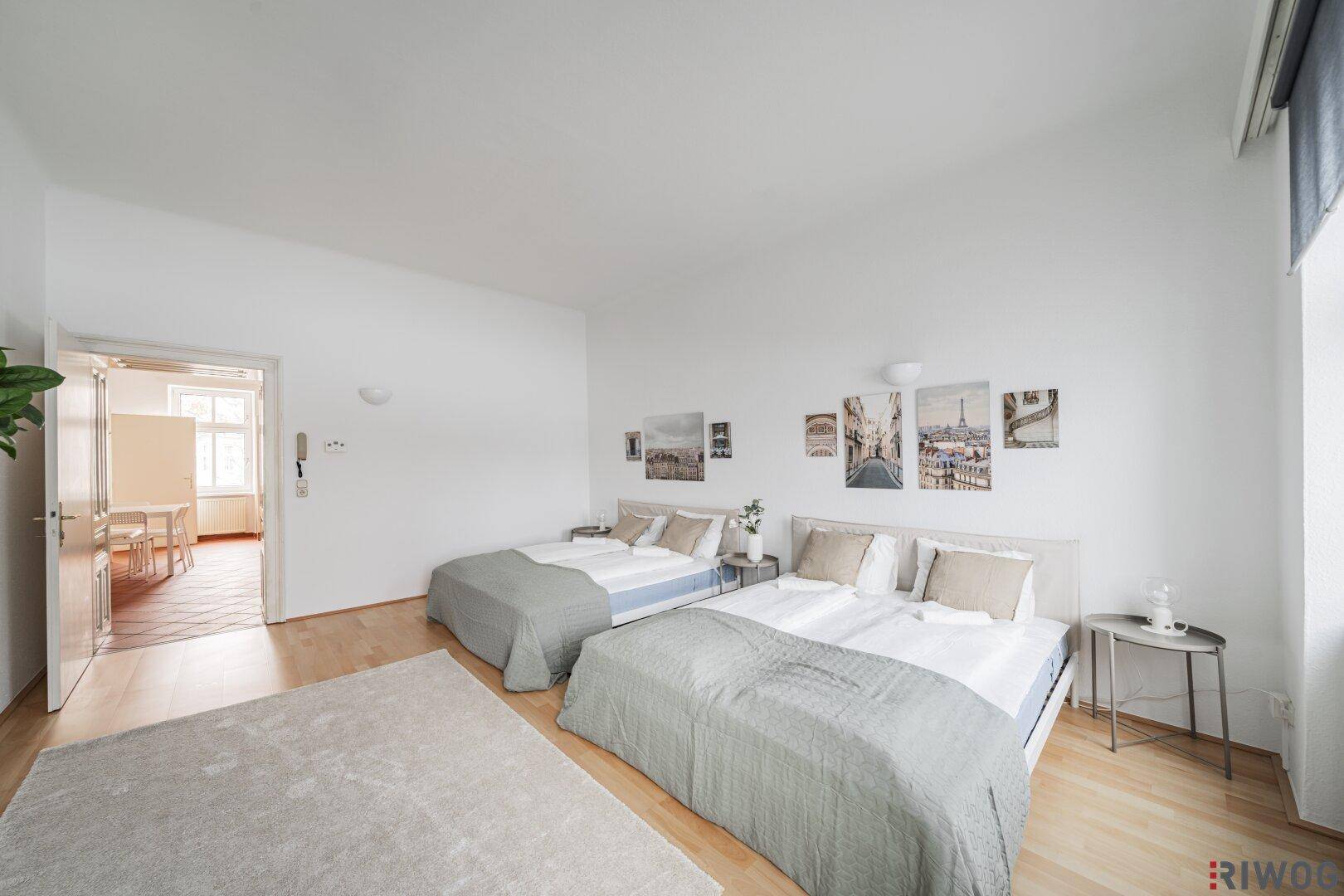 Geräumiges Schlafzimmer mit Holzboden und Zugang zu einem weiteren Raum, hell und einladend.