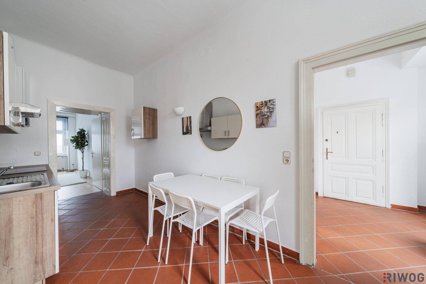 Helle Küche mit Essbereich und Terrakottafliesen, direkter Zugang zum Eingangsbereich der Wohnung.