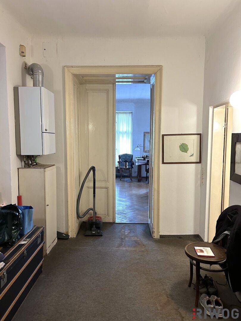 Flur mit Gastherme und Durchgang zu einem weiteren Raum.