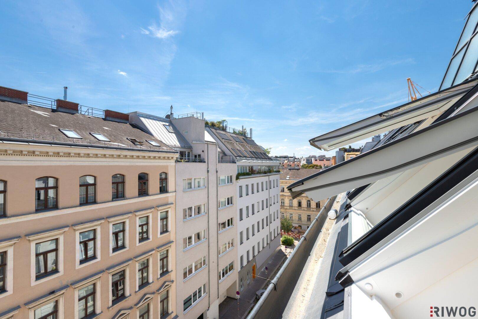 Weitblick über die Dächer der Stadt und eine belebte Straße mit historischen Gebäuden.