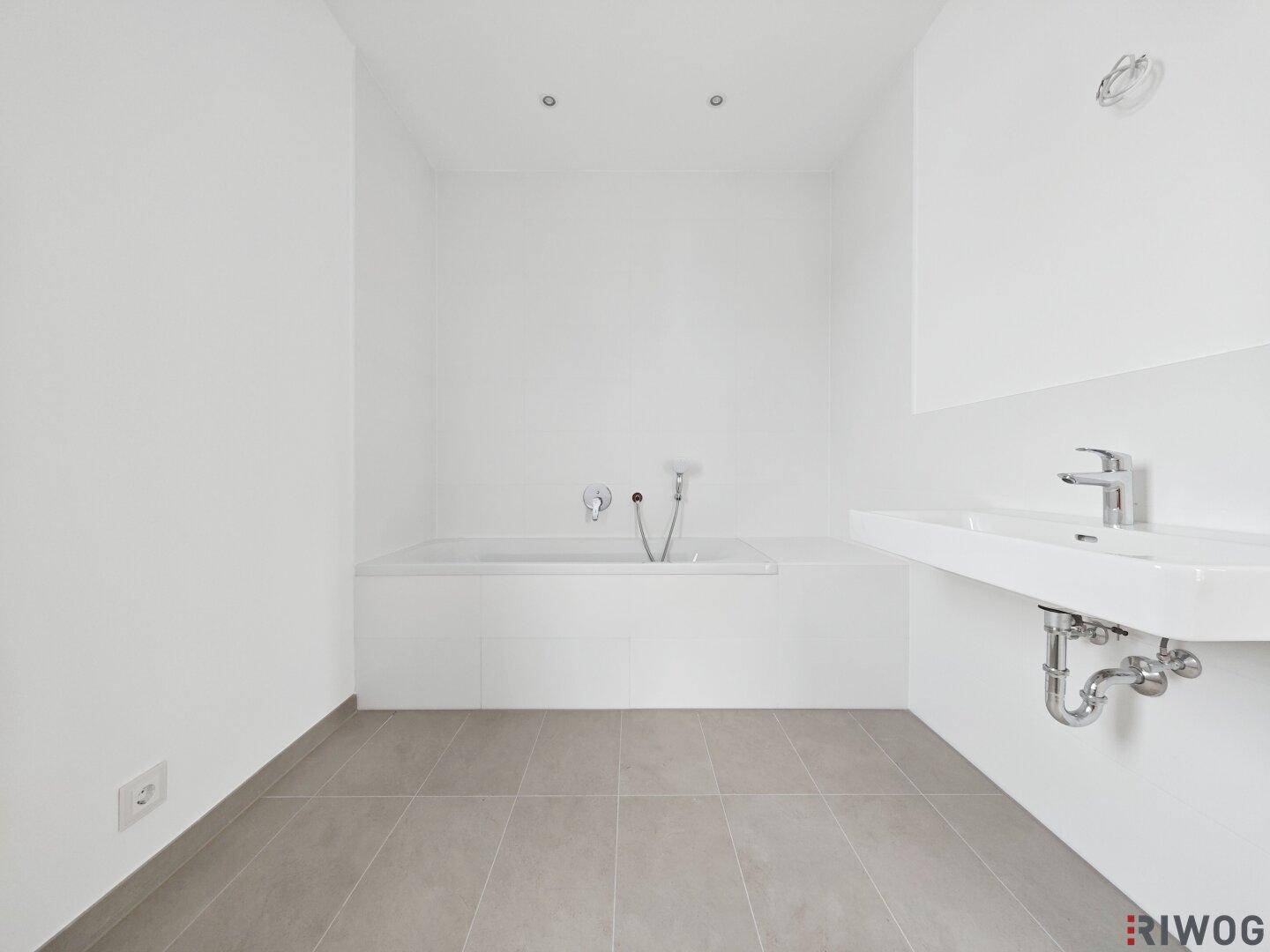Modernes Badezimmer mit Badewanne und Waschtisch, bereit für die Endmontage.