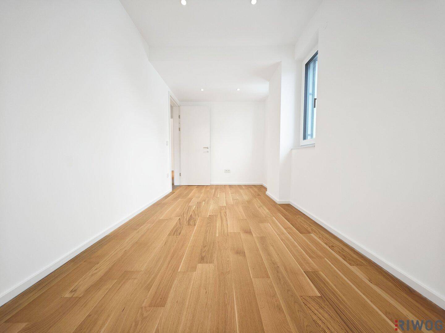 Helles Zimmer mit Parkettboden und Fenster, ideal als Schlaf- oder Arbeitszimmer.