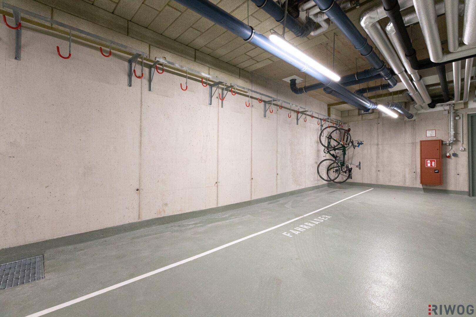 Fahrradraum in der Tiefgarage mit Wandhalterungen und Betonboden.