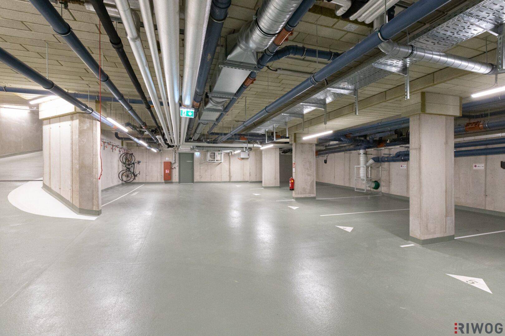 Geräumige Tiefgarage mit Betonstützen und klar markierten Parkplätzen.