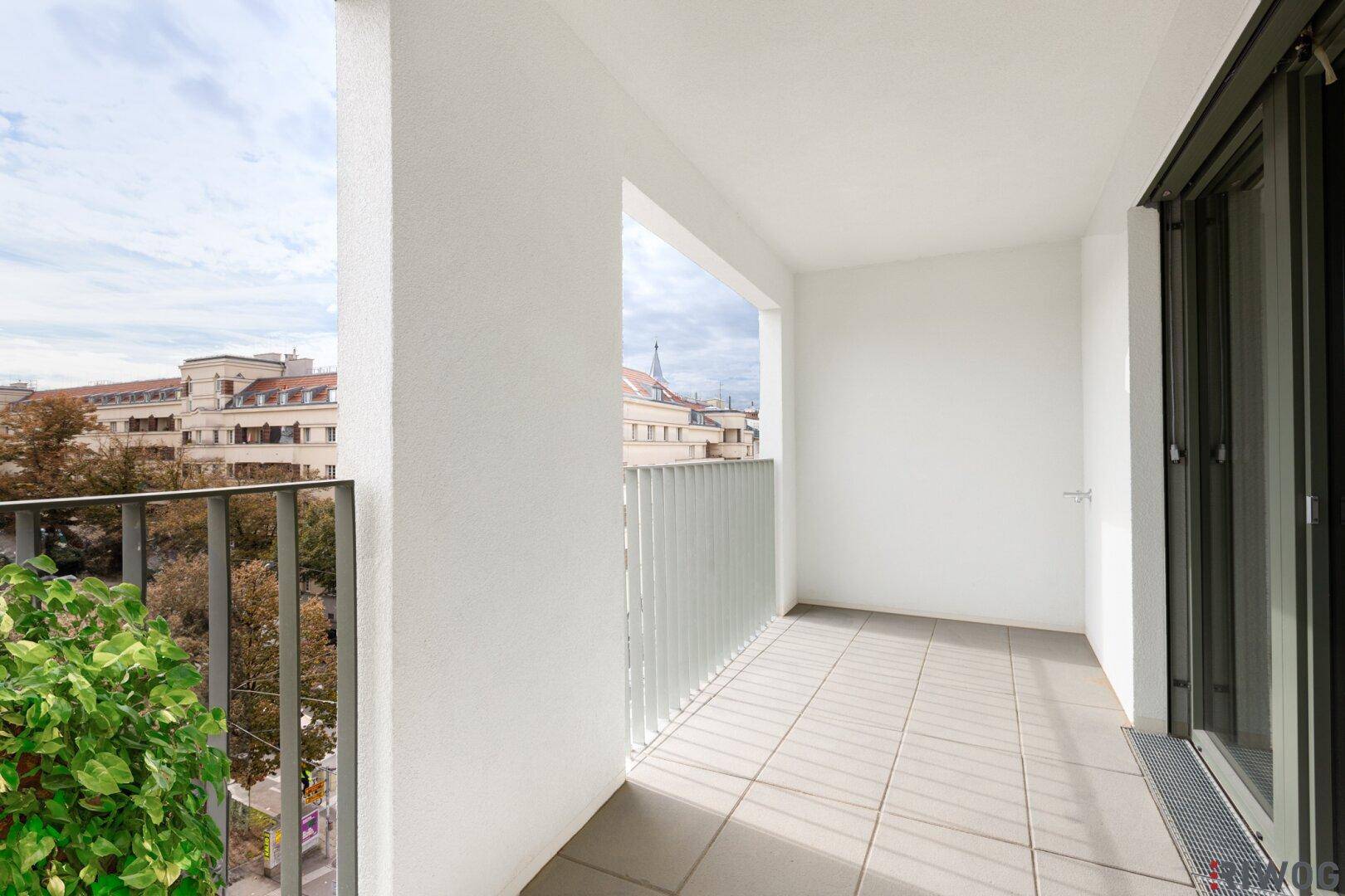 Geräumiger Balkon mit moderner Brüstung und urbanem Ausblick, perfekt für sonnige Tage.