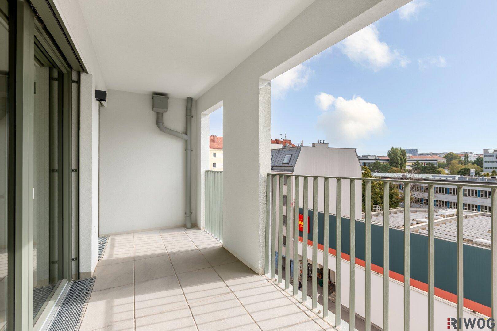 Heller Balkon mit Fliesenboden und Blick auf die Stadt, ideal für entspannte Stunden im Freien.