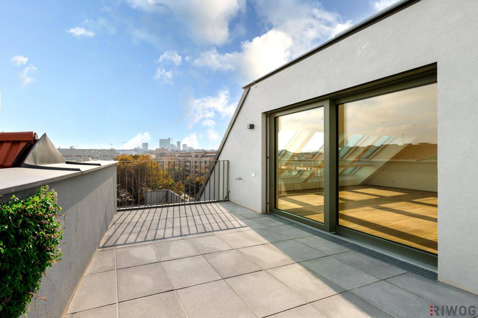 Geräumige Dachterrasse mit Fliesenboden und weitem Blick über die Stadtlandschaft.