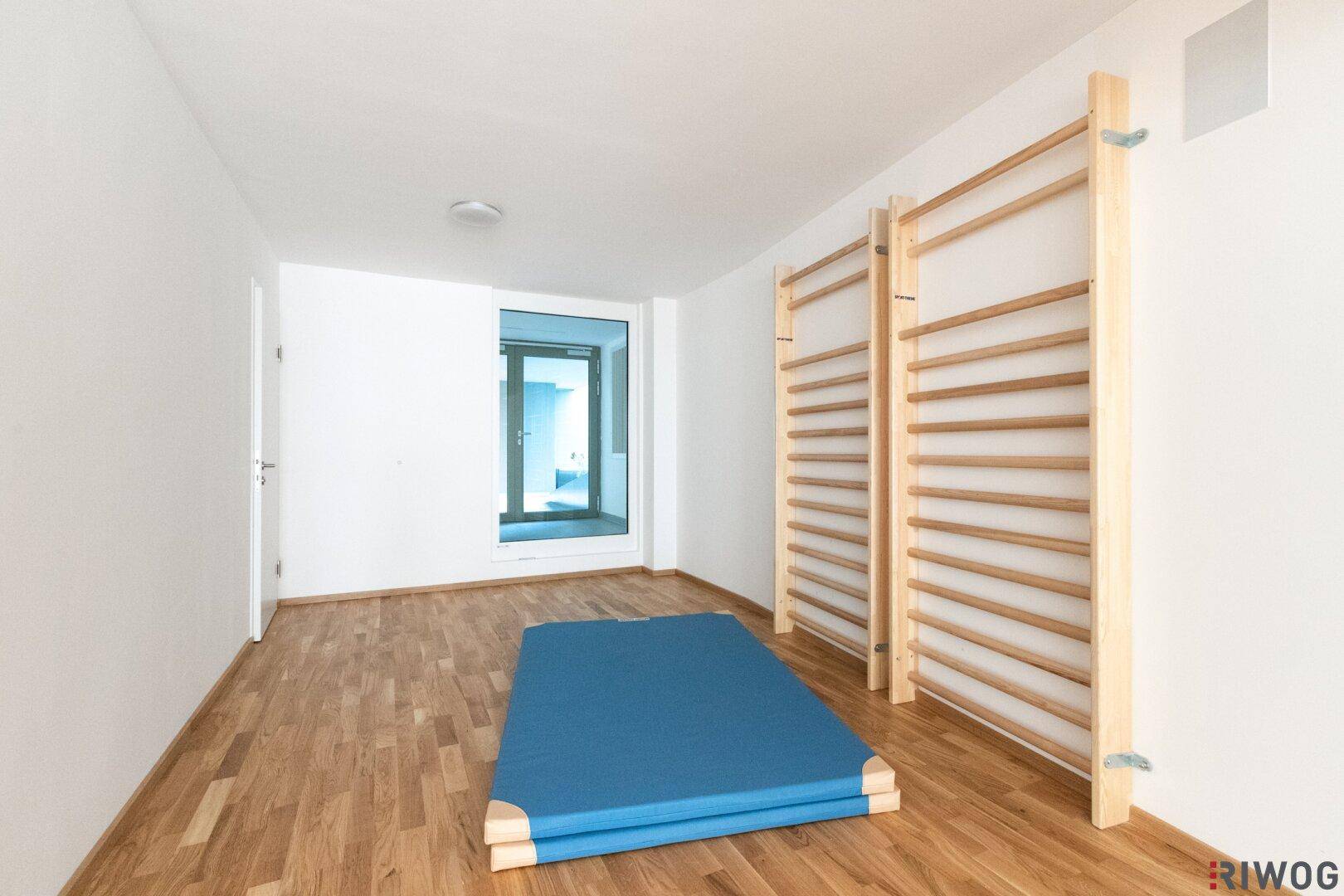 Sport- und Spielraum mit Sprossenwänden und Gymnastikmatte, ideal für Bewegung.