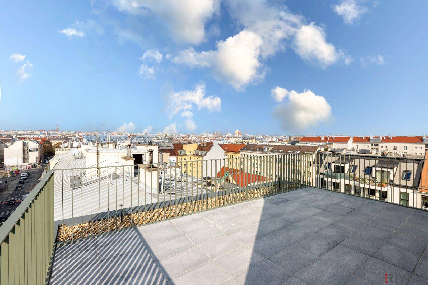 Großzügige Dachterrasse mit weitem Stadtblick und moderner Brüstung, perfekt für Entspannung.