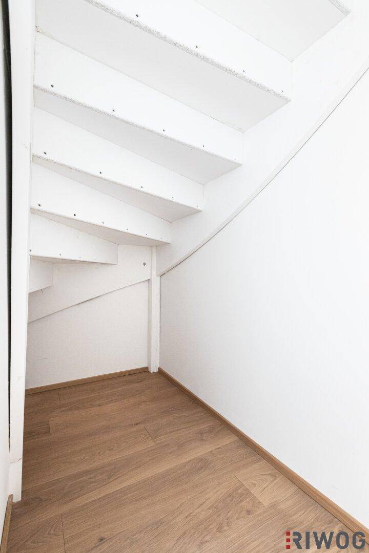 Bereich unter der Treppe mit Holzboden, ideal als Abstellfläche oder kleine Nische.