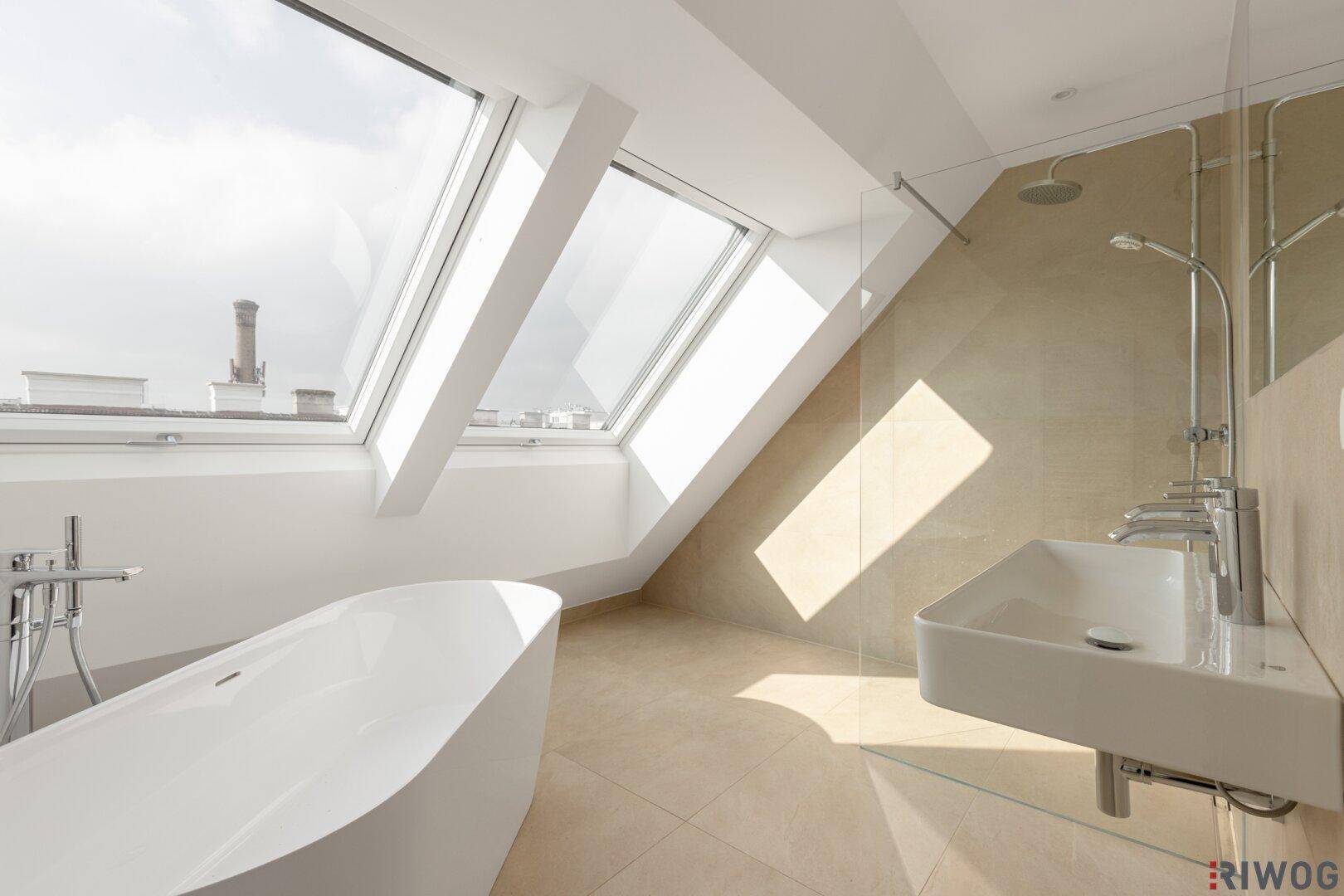 Modernes Badezimmer im Dachgeschoss mit freistehender Badewanne, Dusche und Dachfenstern.