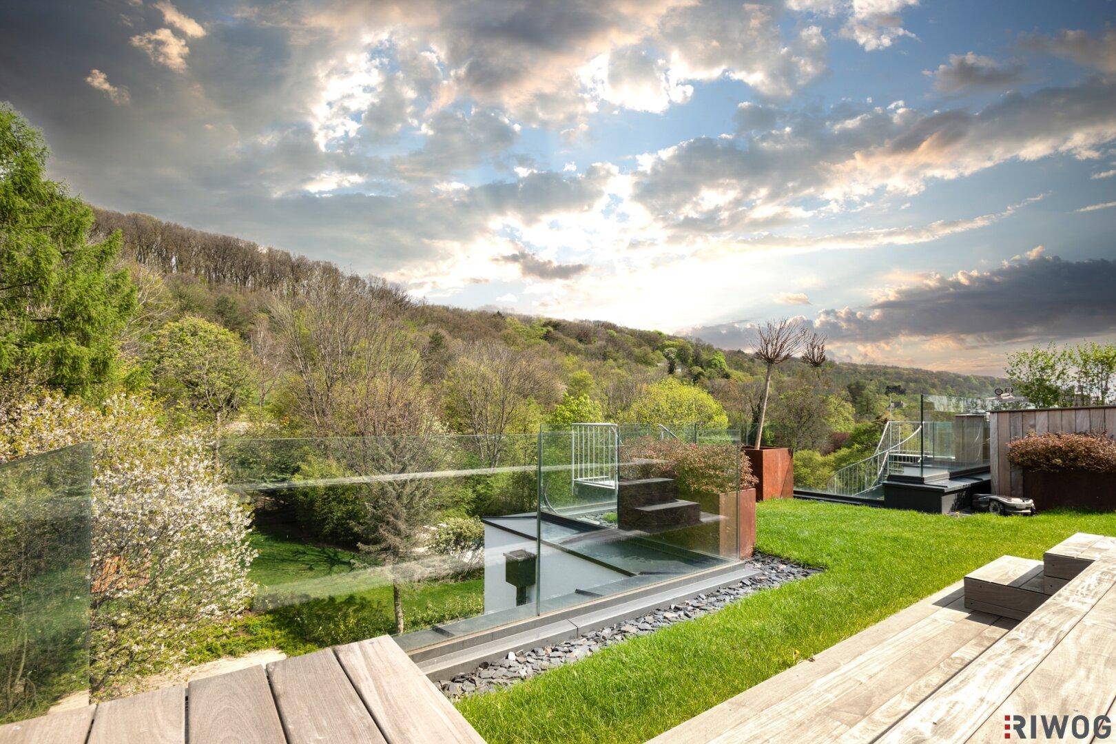 Luftaufnahme eines modernen Wohnkomplexes mit grünen Dächern und Terrassen, eingebettet in die Landschaft.