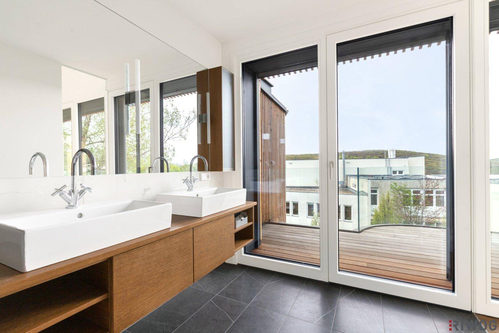 Schlafzimmer mit Holzboden und gebogener Fensterfront, bietet einen Blick auf die Dächer der Nachbarschaft.
