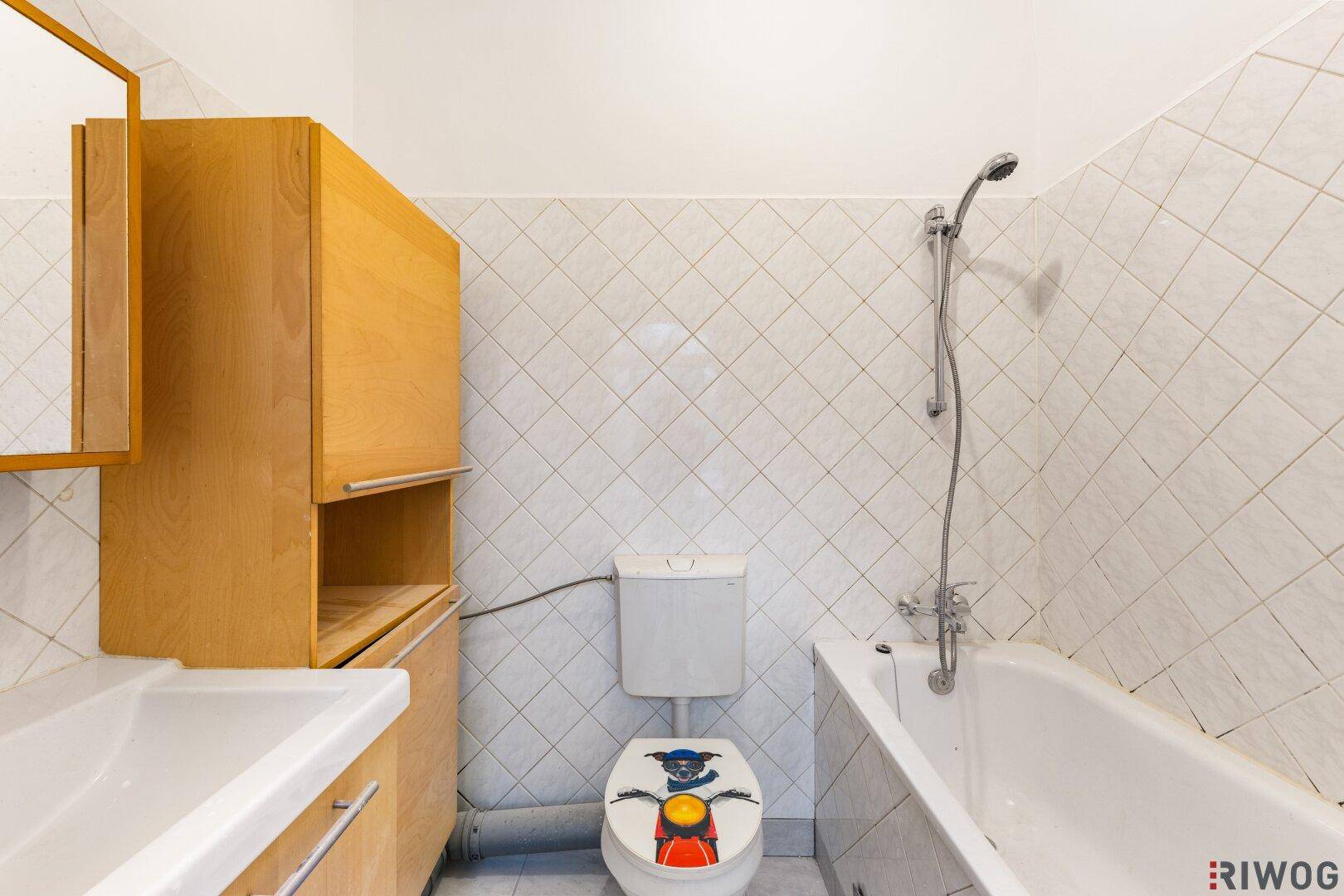 Badezimmer mit Badewanne, Waschbecken und WC, ausgestattet mit hellen Fliesen.