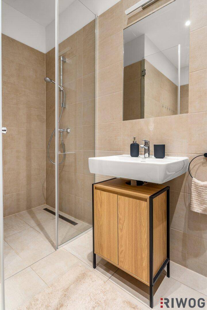 Detailansicht des modernen Badezimmers mit bodengleicher Dusche und stilvollem Waschtisch.
