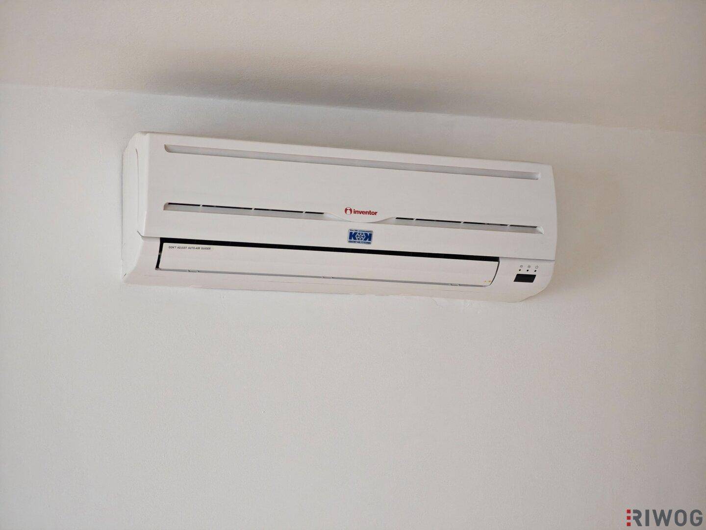Nahaufnahme einer an der Wand montierten Klimaanlage, die für Kühlung sorgt.